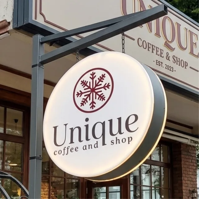 Kafe girişinde direğe asılı yuvarlak ışıklı fener tabela
