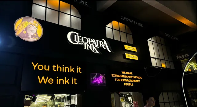 Dövme stüdyosu cephesinde ışıklı pleksi yazı ve logo